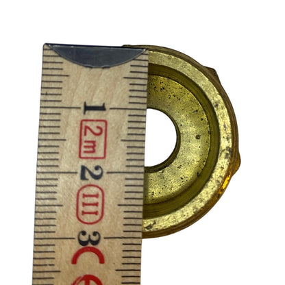 Närbild mässingsreducering med 22 mm öppning och 10 mm genomgående hål uppmätt med tumstock
