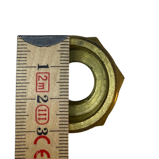 Närbild reducerande bussning mässing med 22 mm och 15 mm innerdiameter uppmätt med tumstock