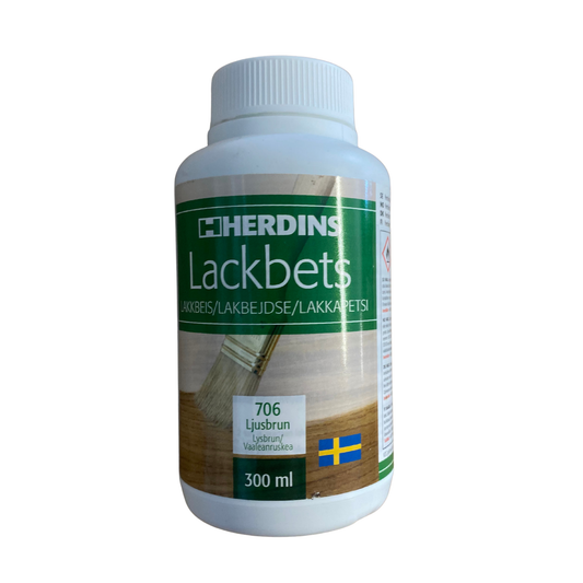 Flaska Herdins Lackbets 706 Ljusbrun 300 ml med etikett som visar pensel och trä