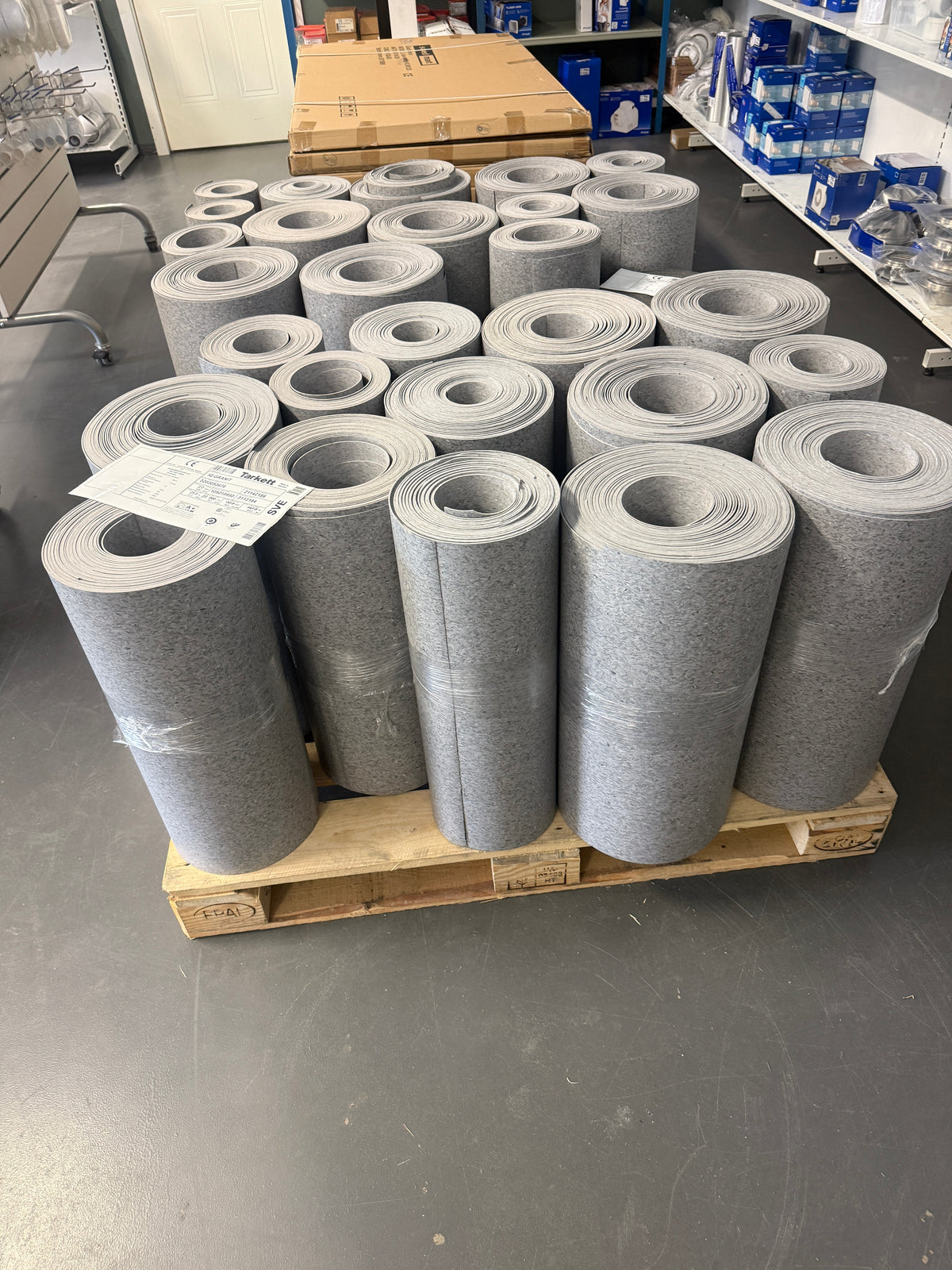 Pall med flera rullar vinylmatta i grått i lager