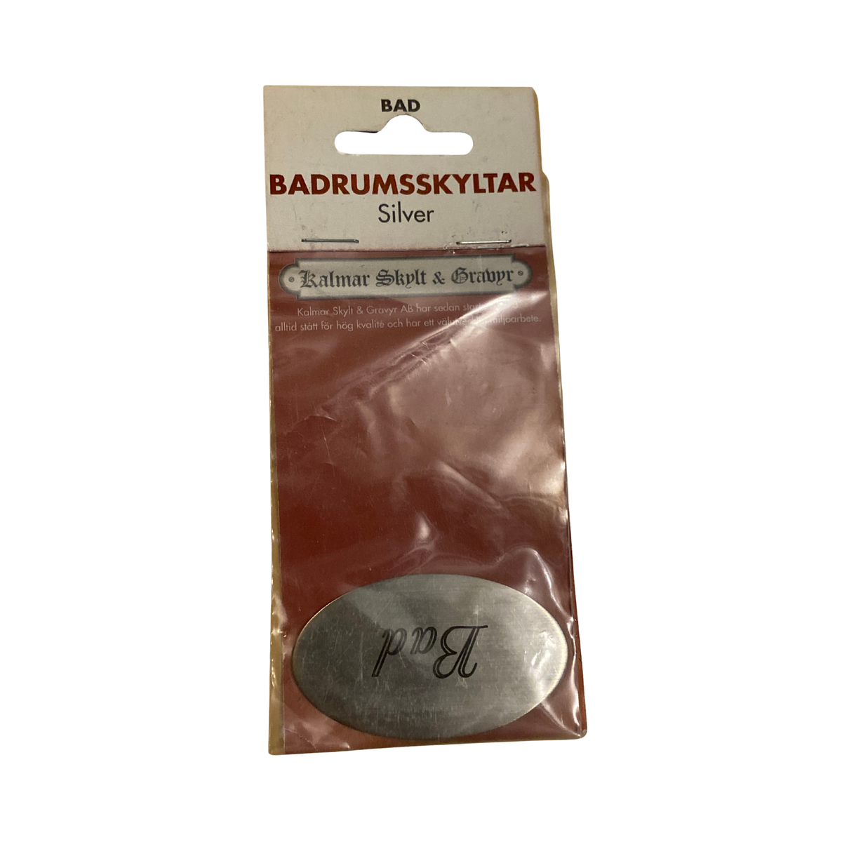 Badrumsskylt Bad i silver, oval med graverad svart text i skrivstil, i originalförpackning